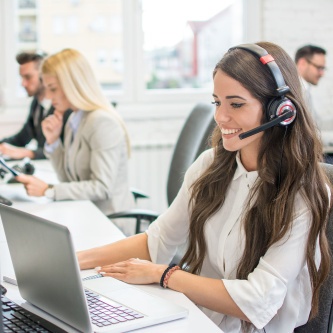 Frau mit Headset am Laptop - symbolisiert den PubliCare Kundenservice